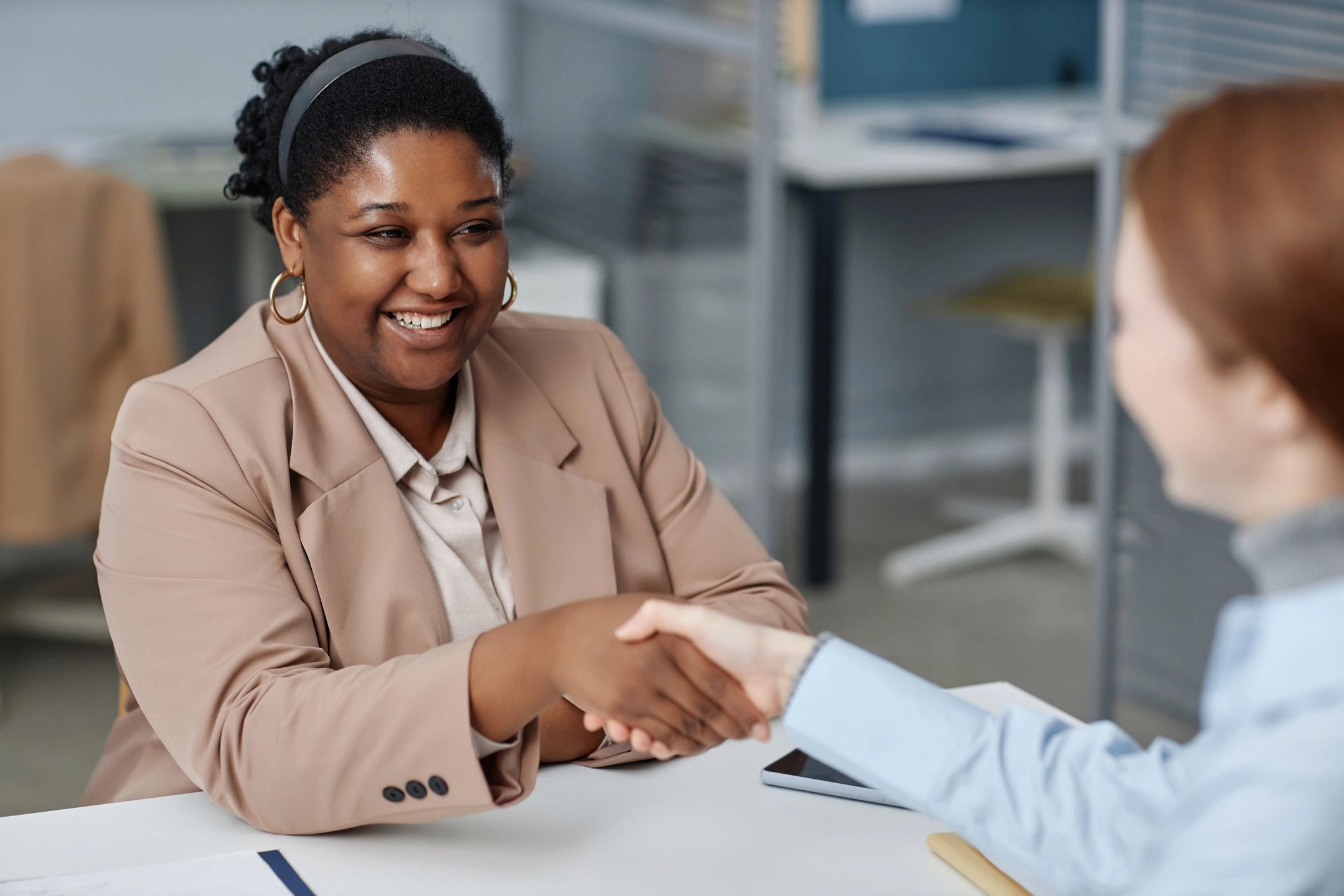HR interviewer greeting a job candidate in an office