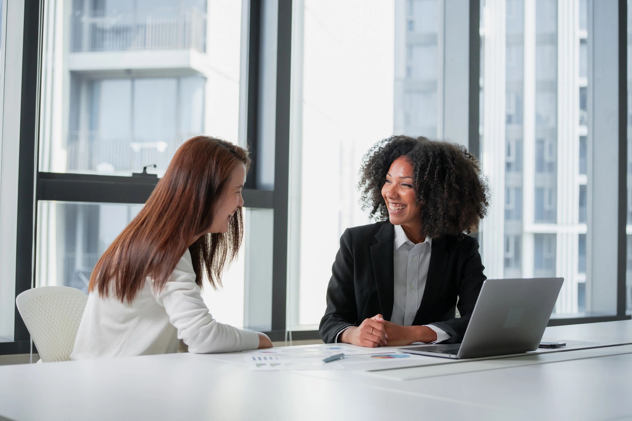 Two professionals reviewing documents in a modern office